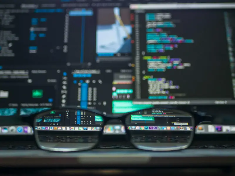glasses focusing on a computer screen with development coding